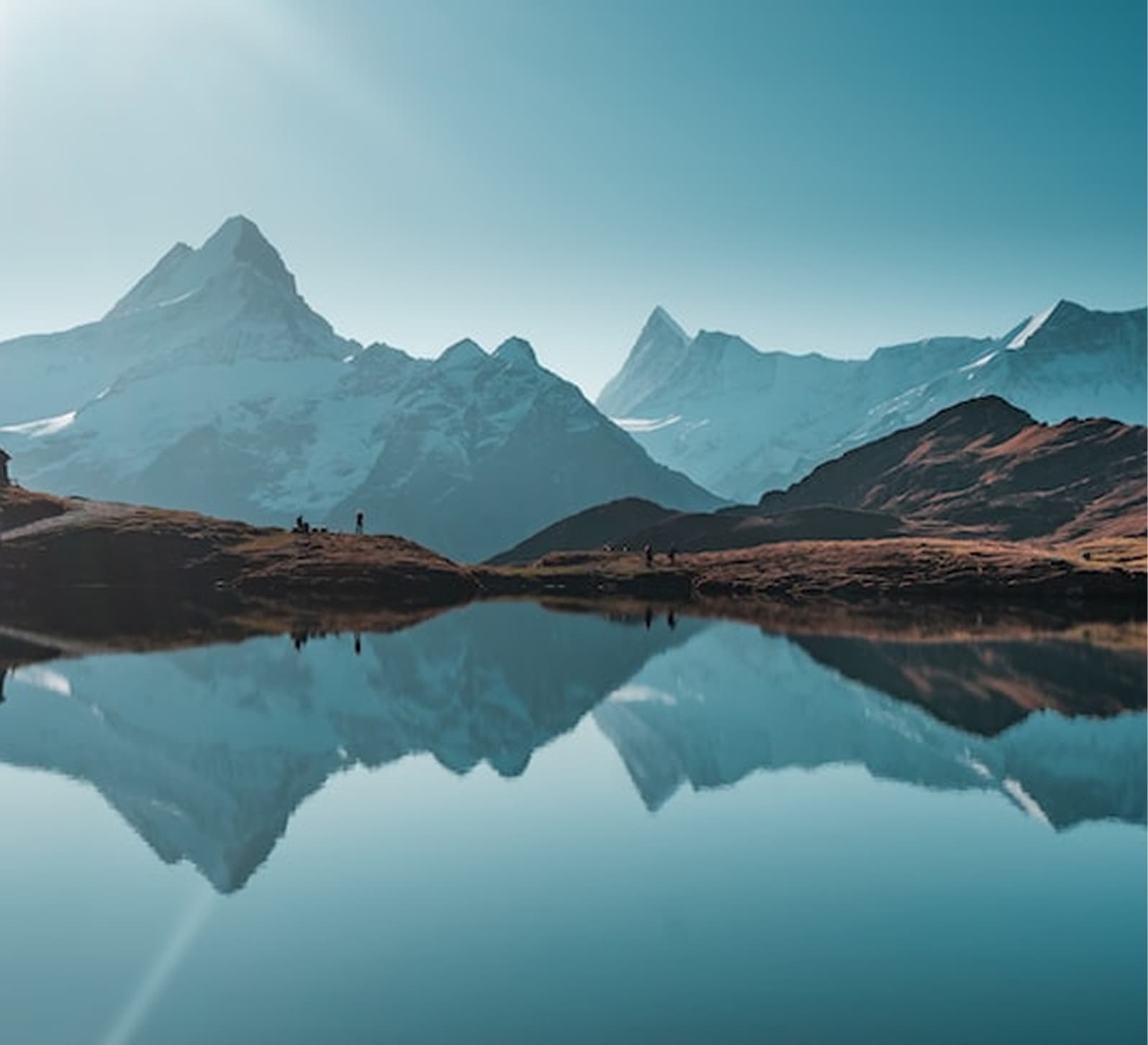 Snowy mountain range reflected in a calm alpine lake
